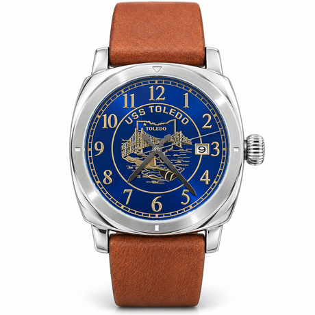 USS Toledo commemorative watch with a blue and gold dial, silver-tone case, brown strap, and date display